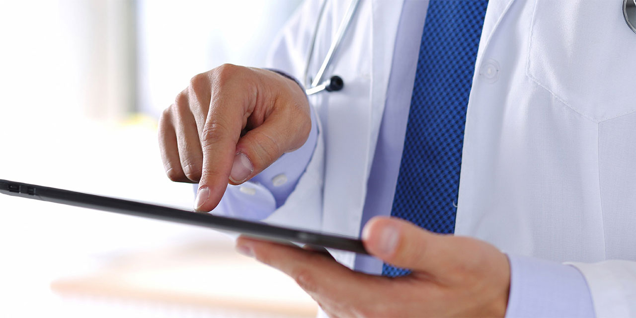 Medical professional holding iPad while wearing lab coat