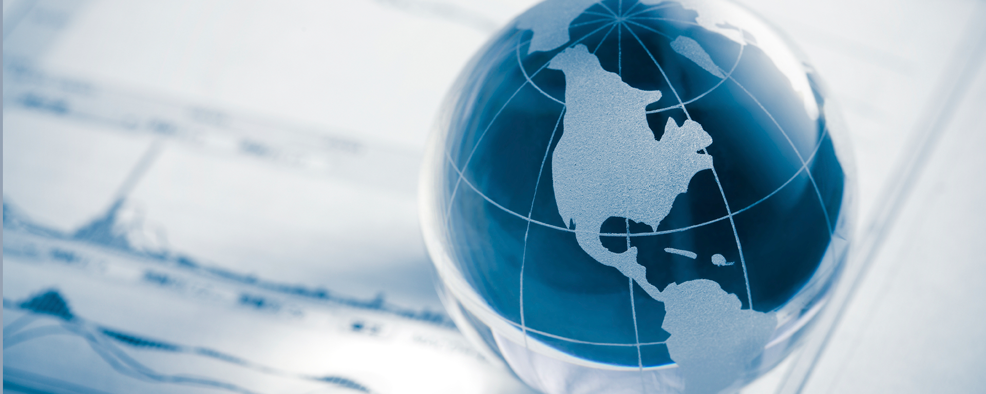 Glass globe sitting on financial papers.