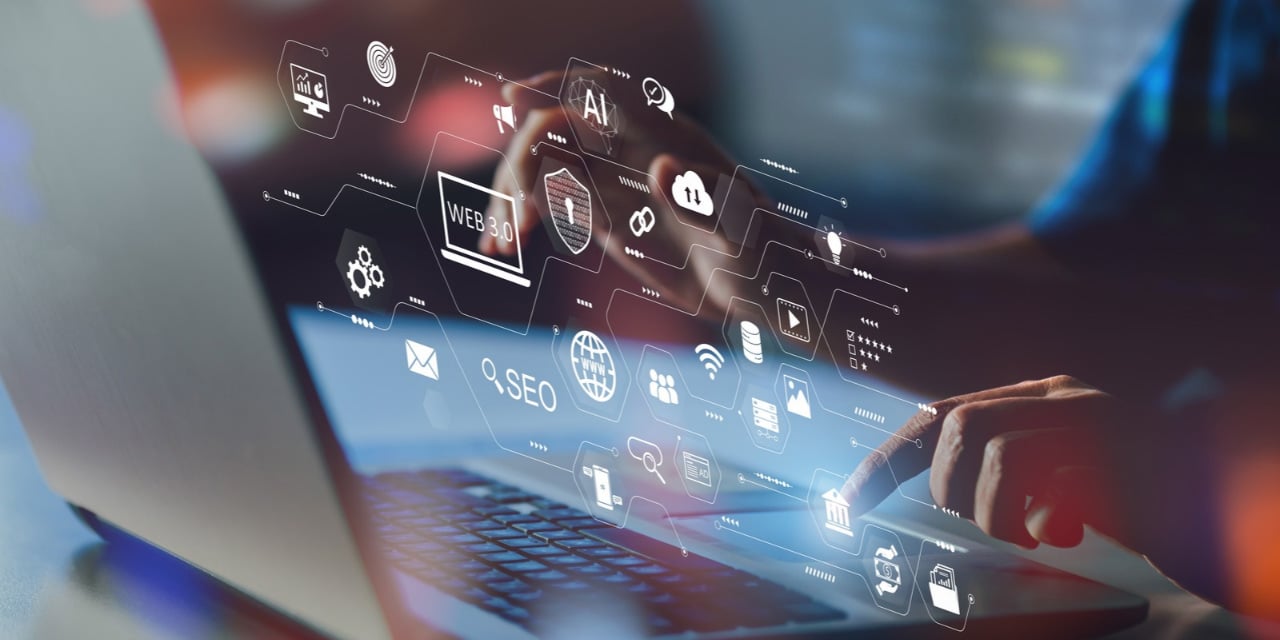 Abstract image of a person using a laptop computer with various web and tech icons floating above it 