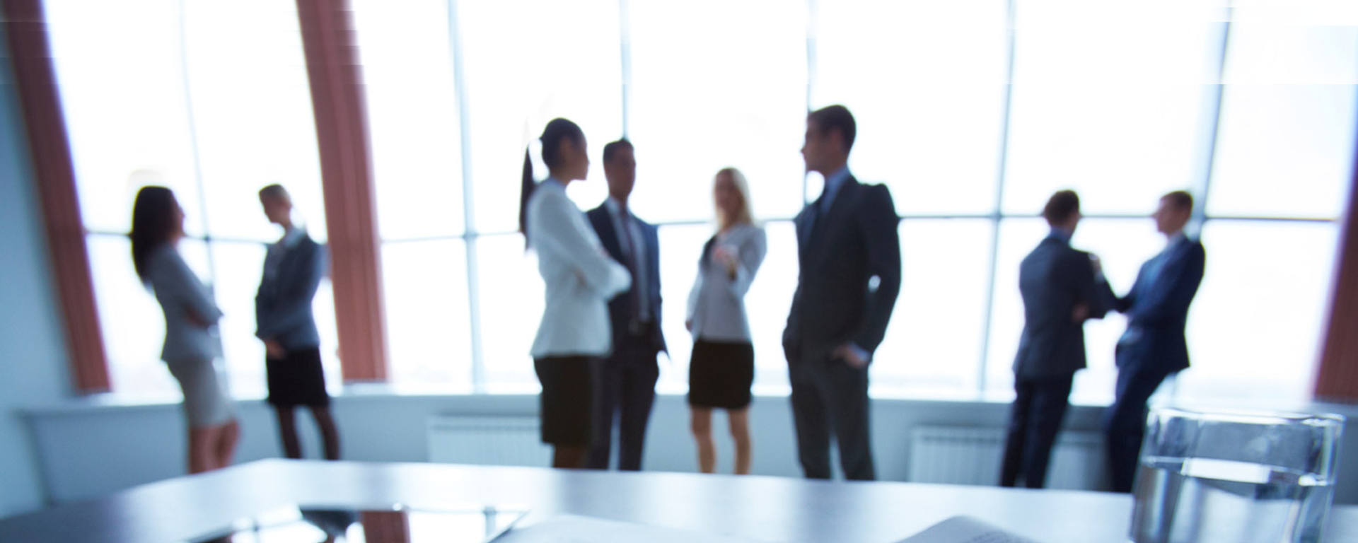 Meeting room filled with professionals talking in groups