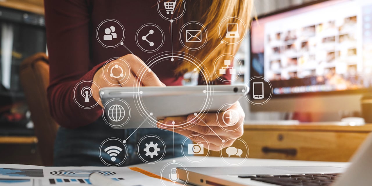 Hands holding a tablet  - social media icons floating over image